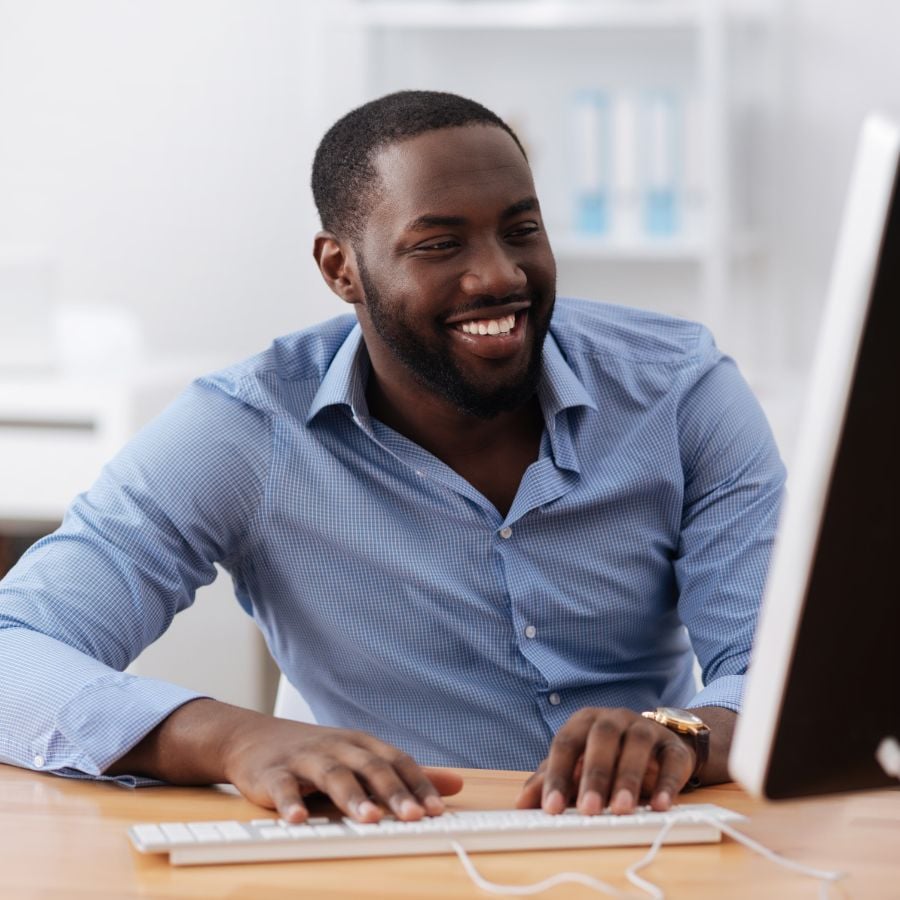 Young black man smiling while working on computer